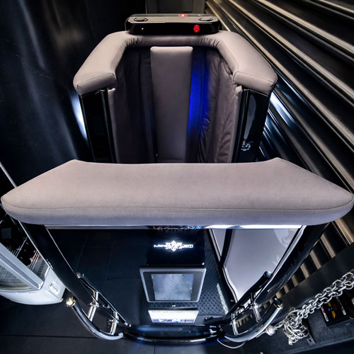 Open cryo sauna showing insulated walls, arm rests, and industrial-grade cold therapy design.